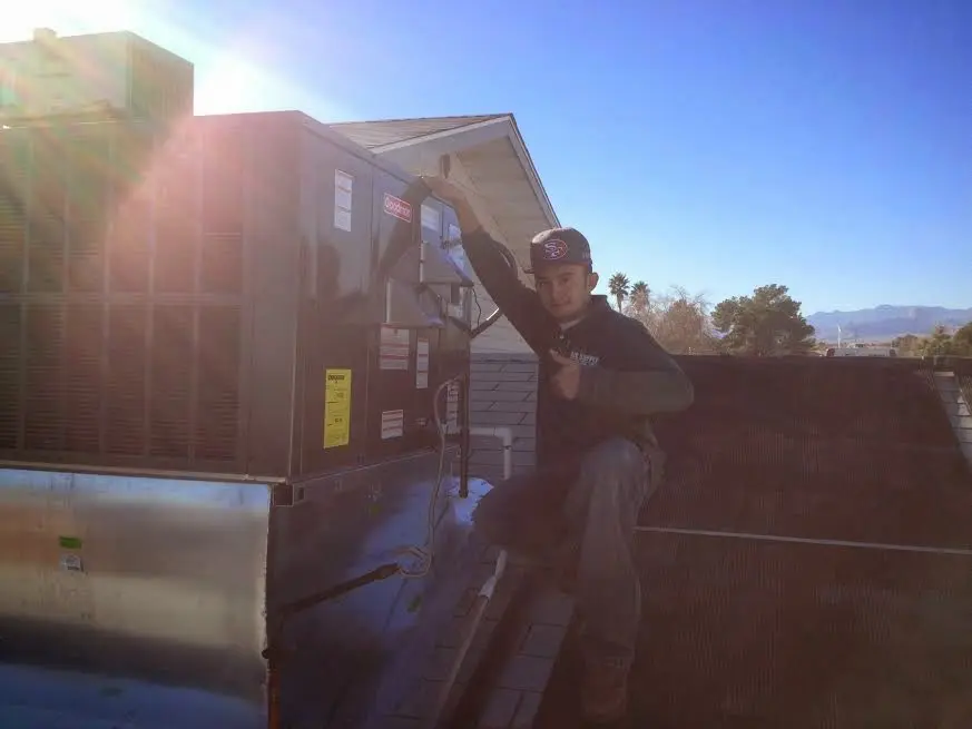 HVAC technician performing AC Tune-Up on a rooftop unit in Willowbrook